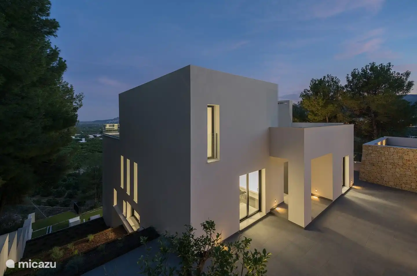 Voor en zij-aanzicht van de villa met daarachter het uitzicht over de vallei