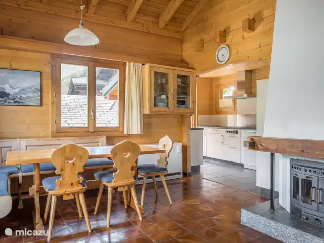 Trimka | Suisse, Valais, Fiesch - appartement salon spacieux avec cheminée où l'on regarde les poutres du toit.