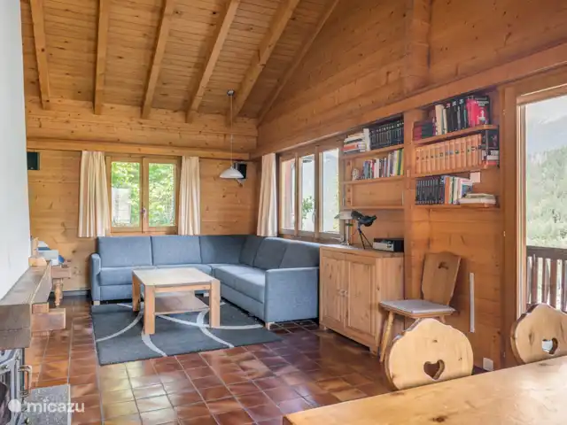 Trimka | Suisse, Valais, Fiesch - appartement salon spacieux avec cheminée où l'on regarde les poutres du toit.