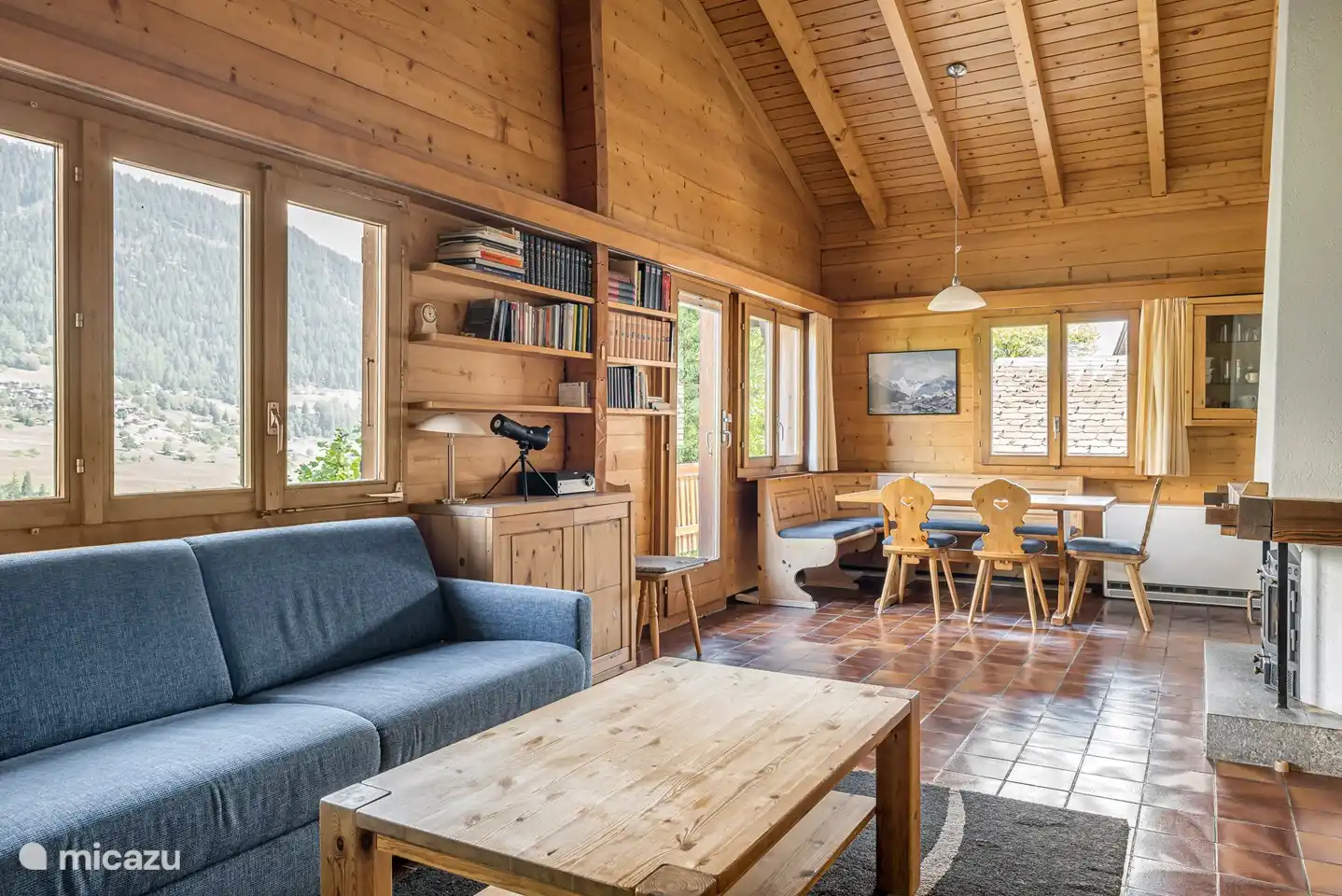 ruime woonkamer met open haard waarbij je kijkt op de dakbalken.