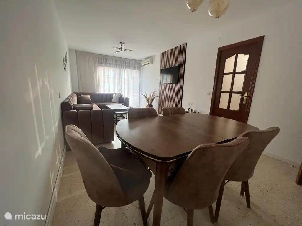 Wohnzimmer mit ausklappbarem Esstisch, an dem die ganze Familie eine Mahlzeit genießen kann.