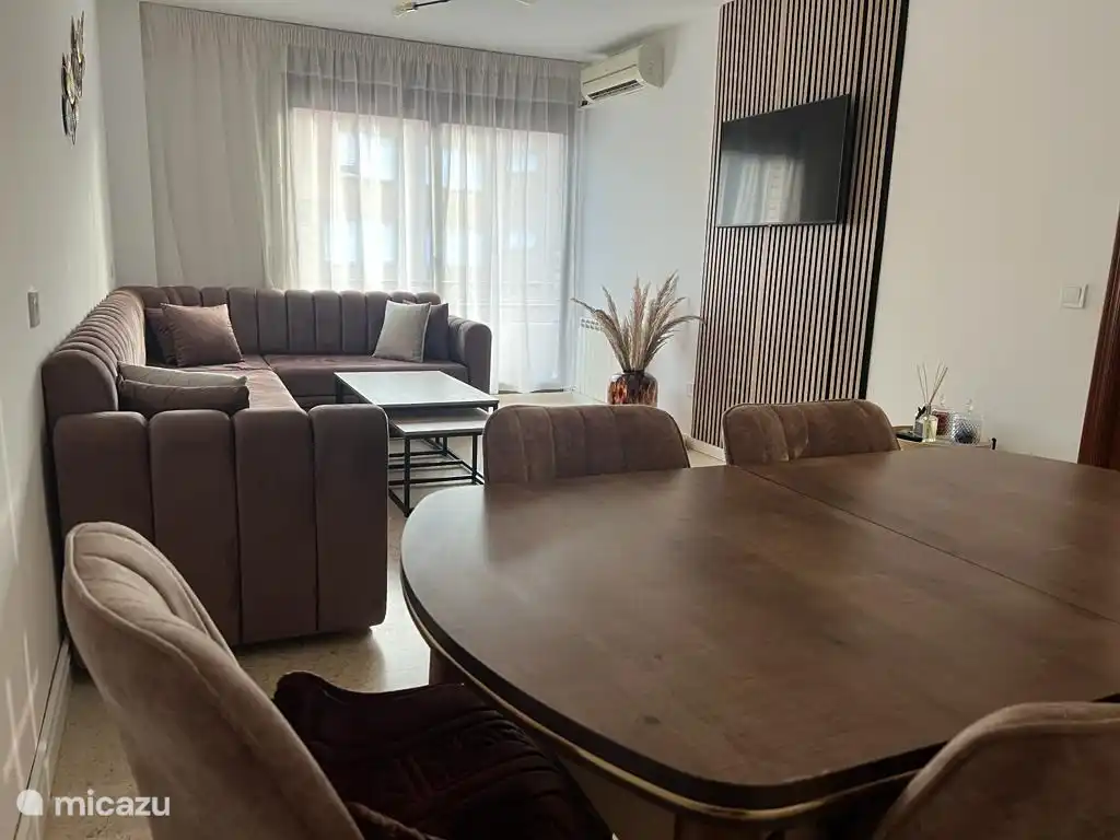 Ein geräumiges Wohnzimmer mit offenen Türen, die zum Balkon führen