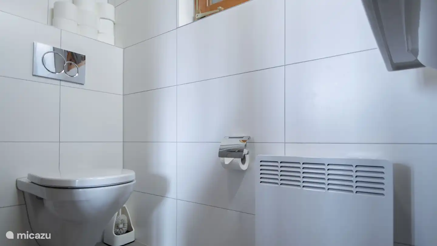 La salle de bain est équipée d'une douche, de toilettes et d'un lavabo.