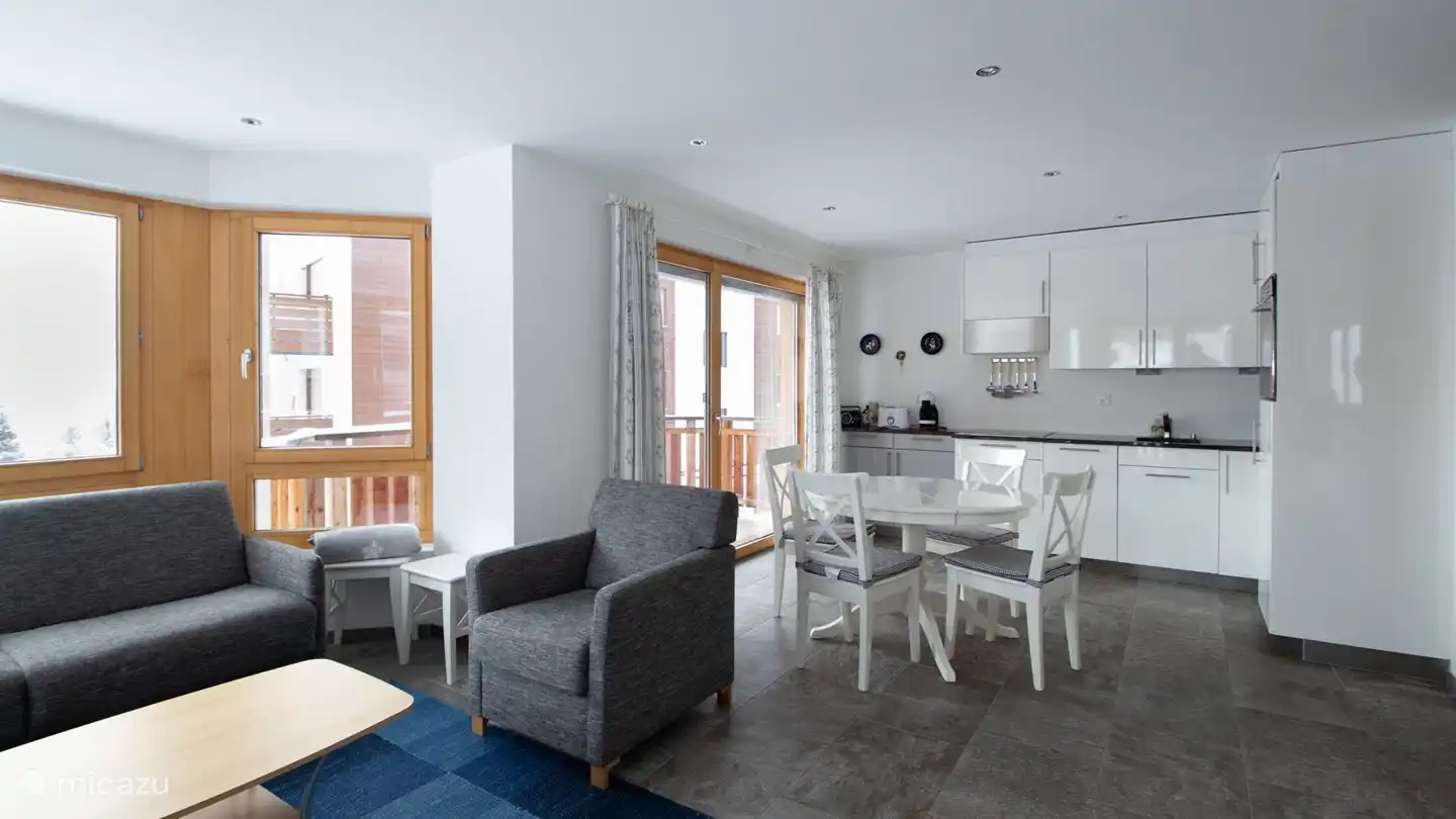 Garderobe, woon/eetkamer met open keuken, de ingebouwde erker geeft de woonkamer een bijzonder tintje. 2 balkons op het oosten en het zuiden bieden geweldige mogelijkheden om de bergen te bewonderen. Prachtig uitzicht op de bergen.