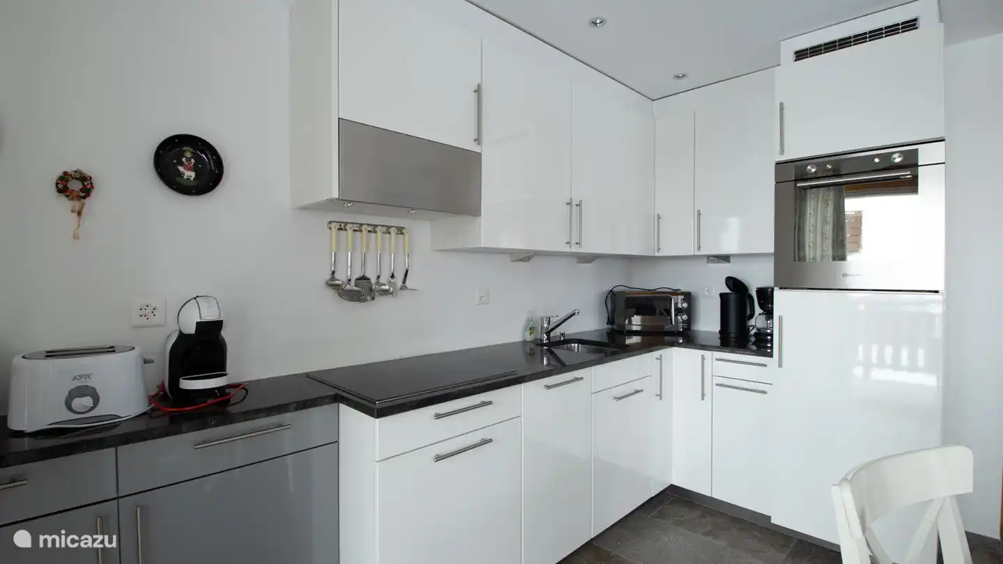 Woon-/eetkamer met open keuken, de ingebouwde erker geeft de woonkamer een bijzonder tintje.