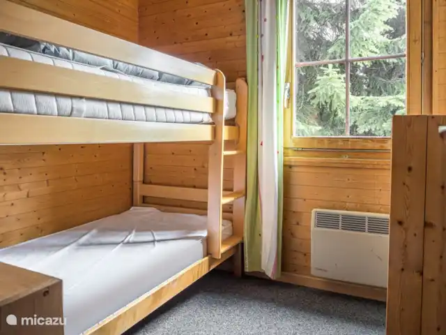 Location de Vacances Suisse, Valais, Bettmeralp, appartement - Jadwiga Parterre La chambre des enfants dispose d'un lit superposé et d'une étagère où se trouvent toutes sortes de jouets.