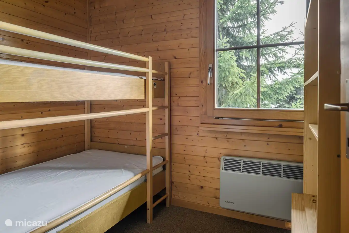 De kinderkamer heeft een stapelbed en een plank waar allerlei speelgoed op te vinden is.