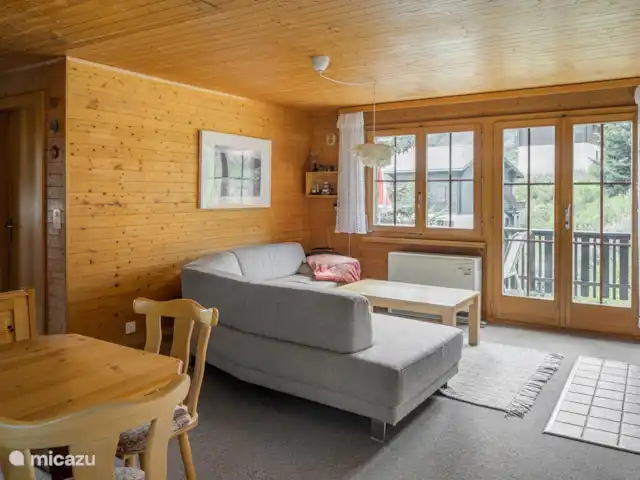 Location de Vacances Suisse, Valais, Bettmeralp, appartement - Jadwiga OG Un salon et une salle à manger ouverts vous invitent à vous attarder. Les soirées plus fraîches peuvent être passées sur le canapé spacieux près de la cheminée.