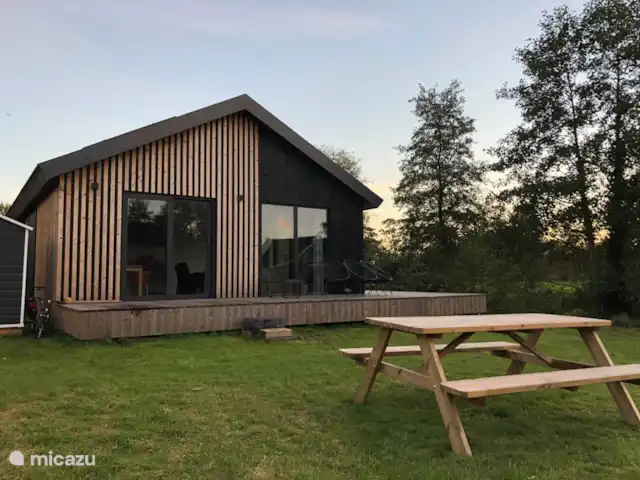 Fietsen, Nederland, Friesland, Oudwoude, bungalow De kolibrie Achterkant van het huis, gezien vanuit de tuin, gelegen aan het water