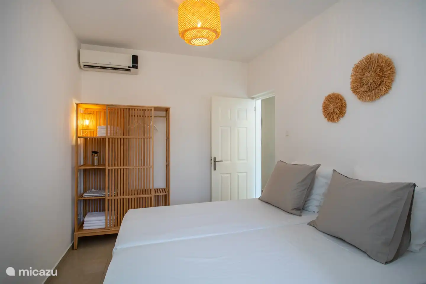 Deuxième chambre avec deux lits simples confortables, douche privative et climatisée pour un confort optimal.