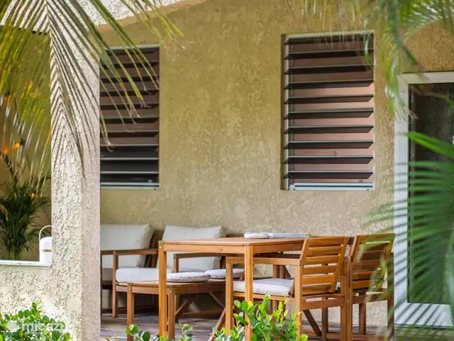 Casa del Viento Curaçao  | Curaçao, Banda Ariba (est), Cas Grandi - appartement Porche spacieux au rez-de-chaussée avec accès direct à la piscine, abrité par des plantes tropicales et des arbres. Comprend un coin salon confortable, une table à manger et un ventilateur de plafond pour plus de confort