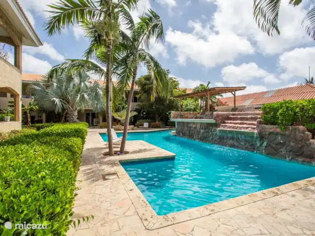 Casa del Viento Curaçao  | Curaçao, Banda Ariba (est), Cas Grandi - appartement Piscine spacieuse et belle avec cascade, transats confortables et une terrasse, parfaite pour se détendre et se rafraîchir.