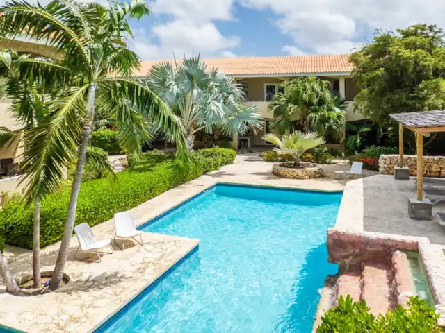 Casa del Viento Curaçao  | Curaçao, Banda Ariba (est), Cas Grandi - appartement Piscine spacieuse et belle avec cascade, transats confortables et une terrasse, parfaite pour se détendre et se rafraîchir.