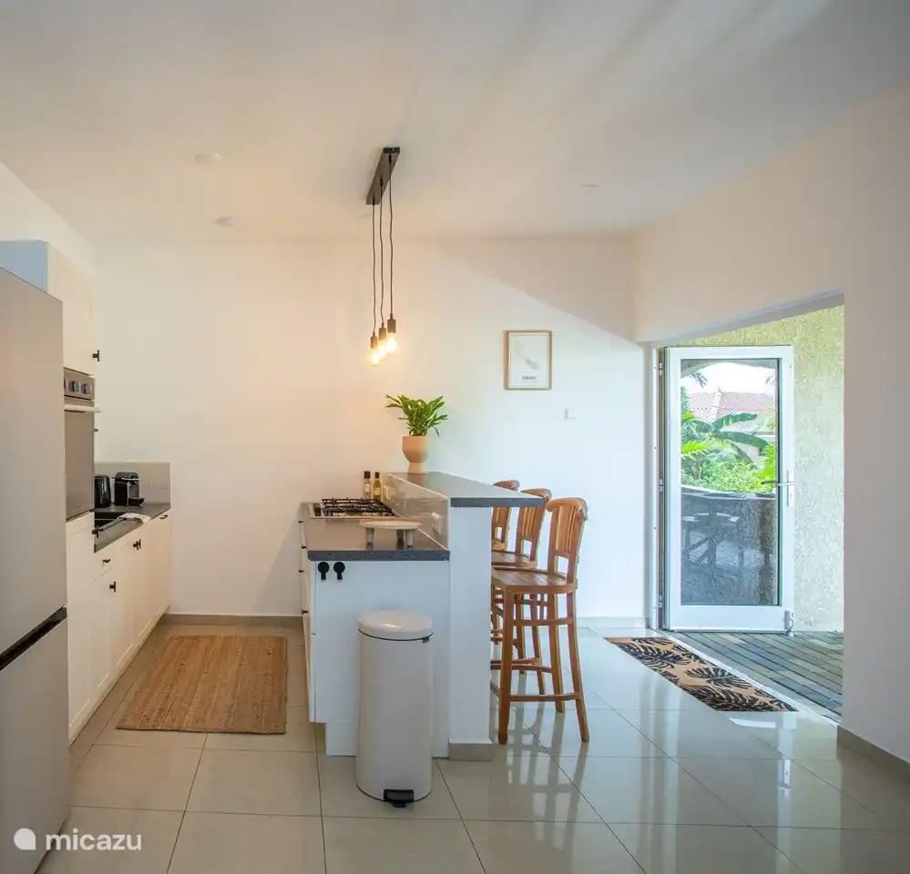 Cuisine confortable et entièrement équipée avec vue sur le porche. Équipé d’un réfrigérateur spacieux, d’un four, d’un lave-vaisselle et de tabourets de bar pour des moments d’ambiance pendant la cuisson.