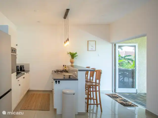 Casa del Viento Curaçao  | Curaçao, Banda Ariba (est), Cas Grandi - appartement Cuisine confortable et entièrement équipée avec vue sur le porche. Équipé d’un réfrigérateur spacieux, d’un four, d’un lave-vaisselle et de tabourets de bar pour des moments d’ambiance pendant la cuisson.