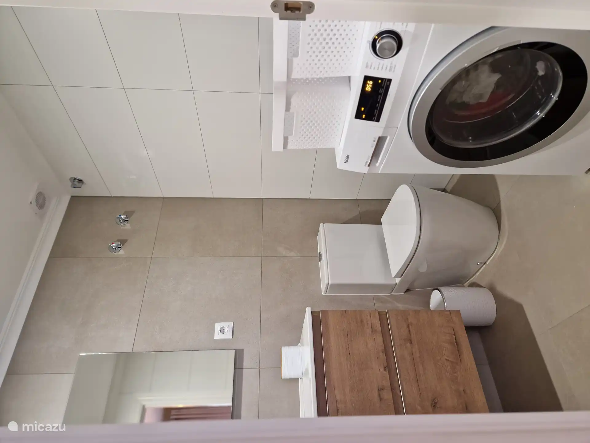 Salle de bain avec machine à laver et toilettes