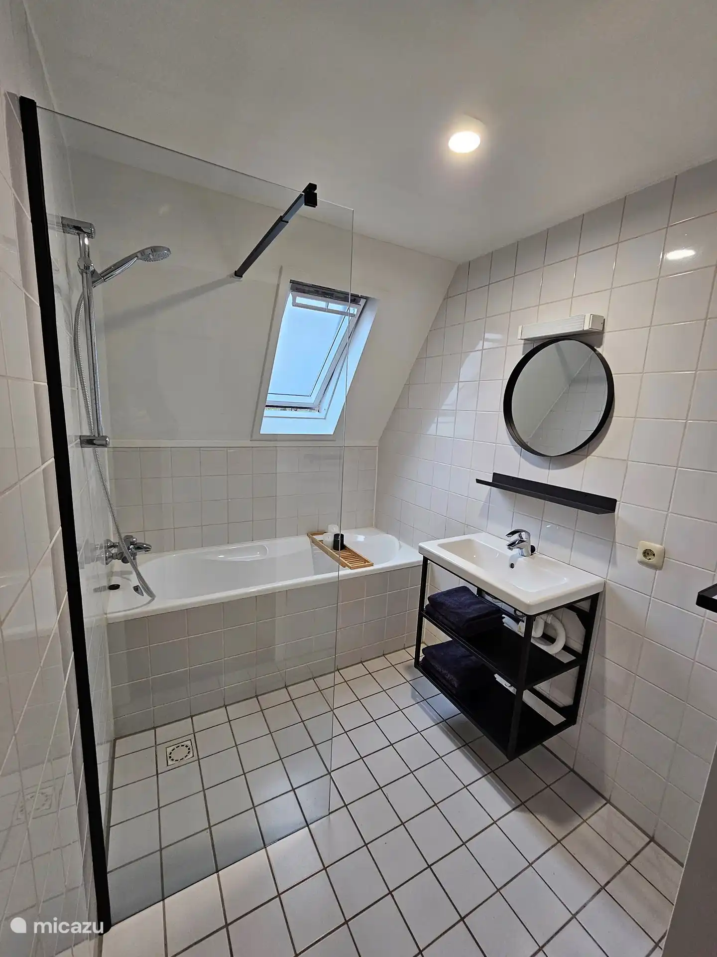 The bathroom, renovated in January 2024, has a bath, walk-in shower and washbasin.