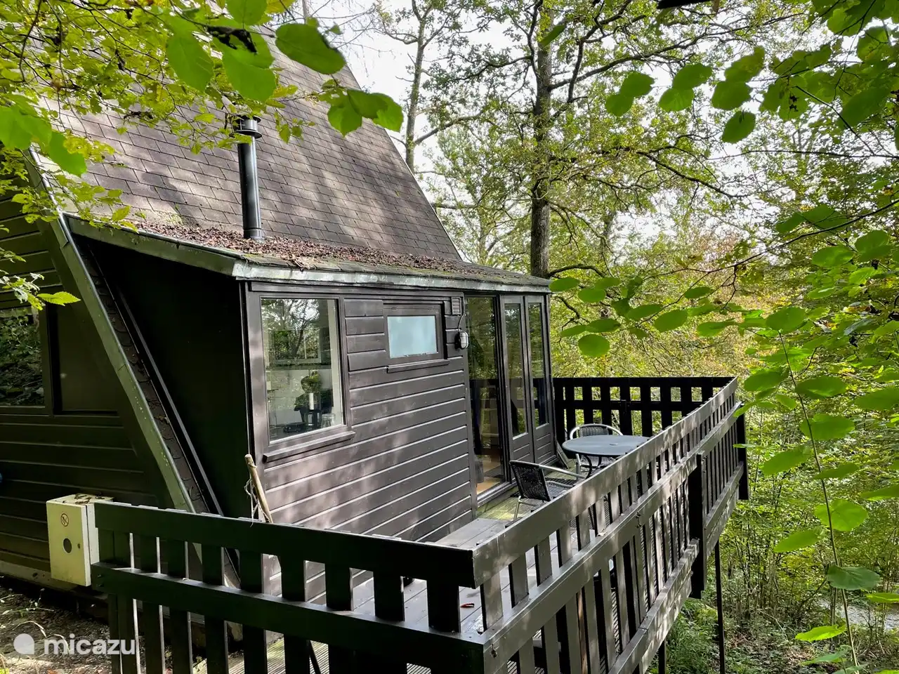 Chaleureuse terrasse sur le côté du Lodge 205. On a l'impression d'être assis parmi les arbres.