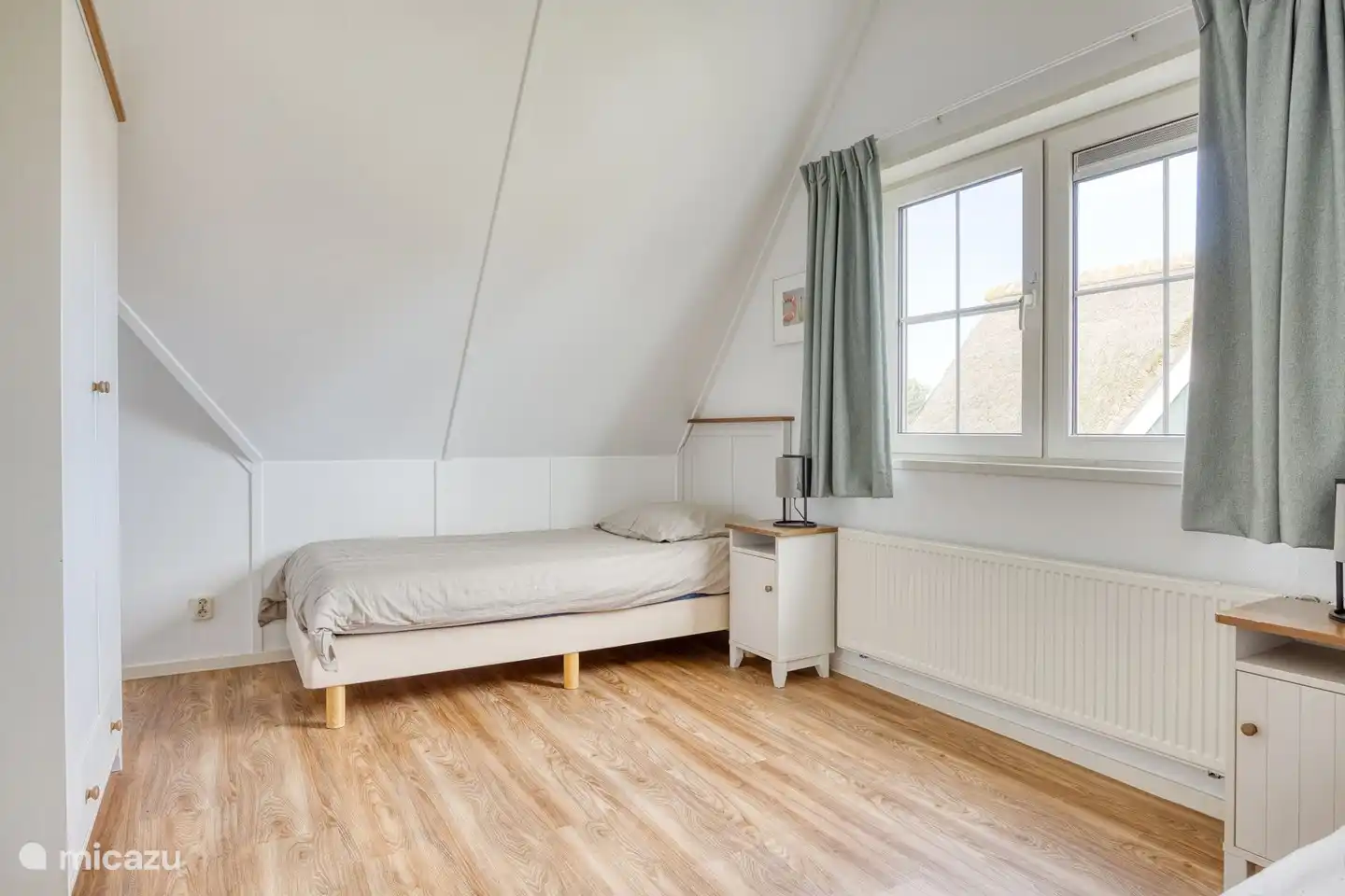 Schlafzimmer 2 mit zwei Einzelbetten und einem Kleiderschrank.