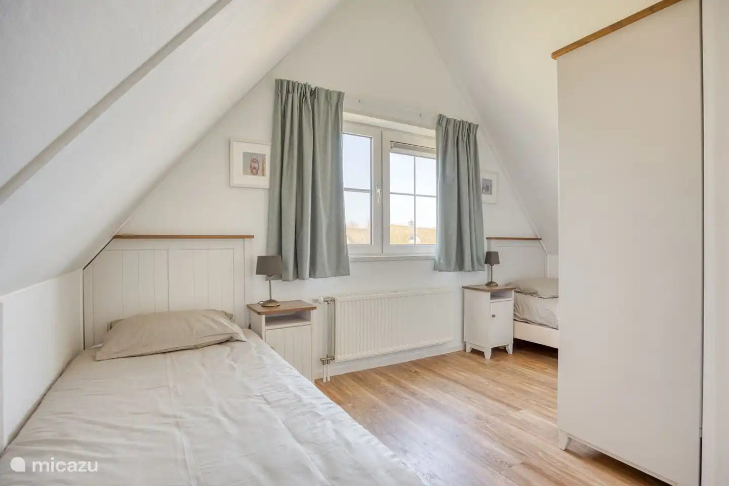 Schlafzimmer 2 mit zwei Einzelbetten und einem Kleiderschrank.