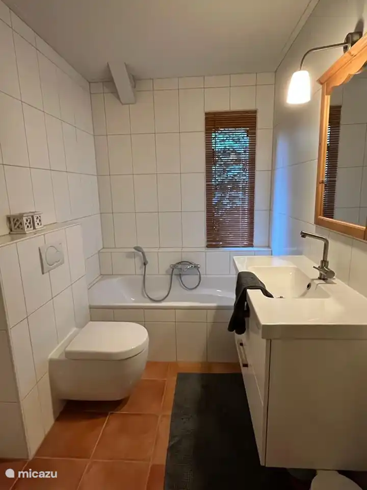 Badkamer met bad en aparte doucheruimte