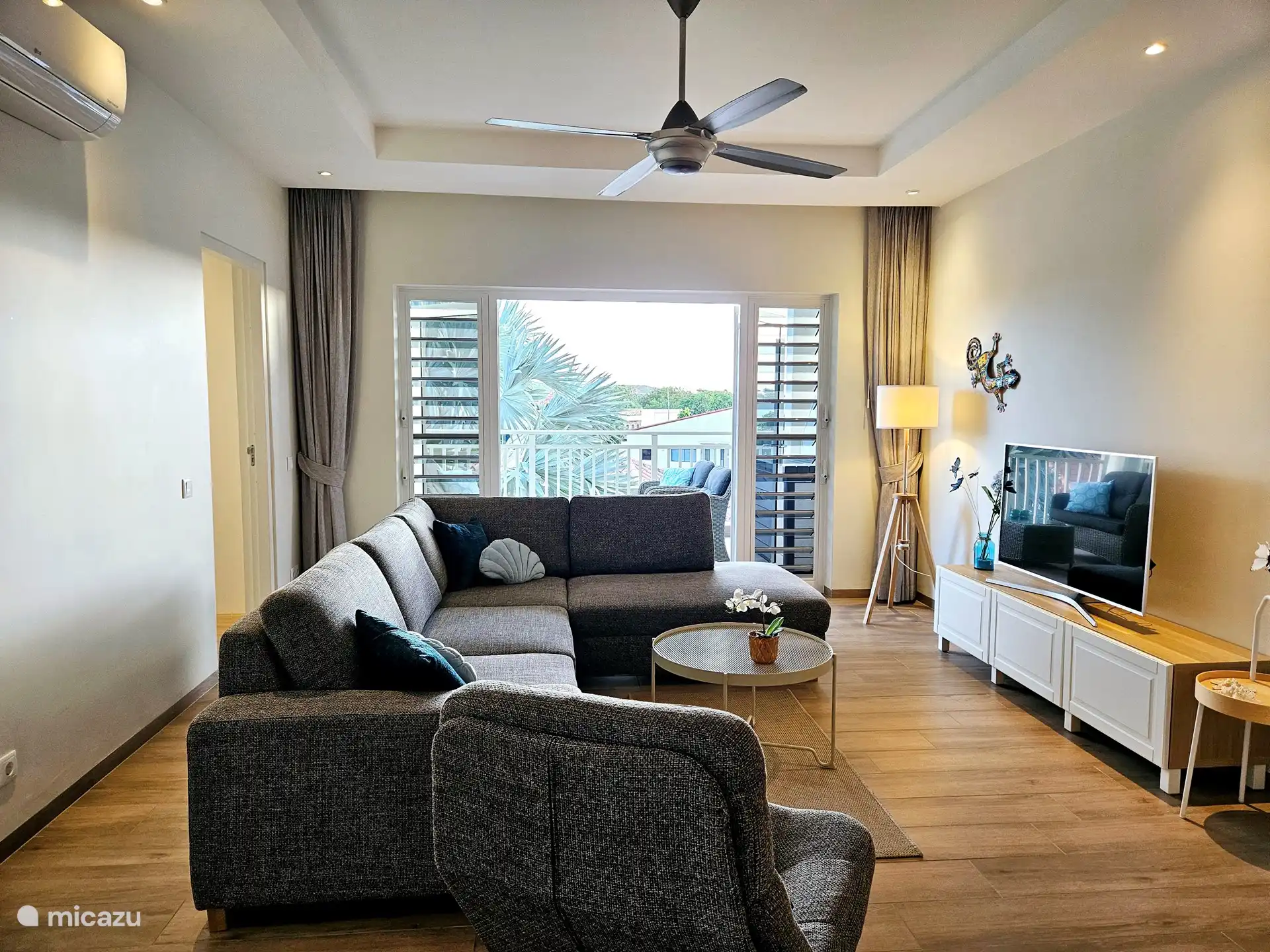 Das geräumige und gemütliche Wohnzimmer mit schönem Sofa, Flachbildfernseher, Klimaanlage und Deckenventilator.