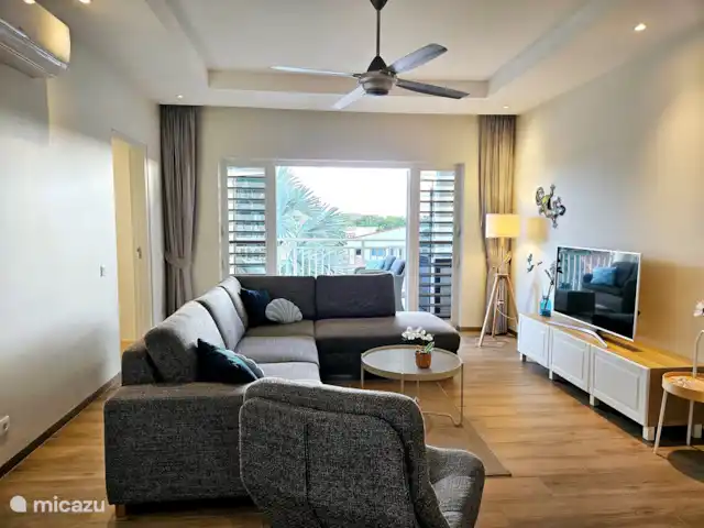 apartamento en Curazao, Curazao Centro, Blue Bay – Casita Caribe + Préstamo de Auto! La amplia y acogedora sala de estar con un hermoso sofá, TV de pantalla plana, aire acondicionado y ventilador de techo.