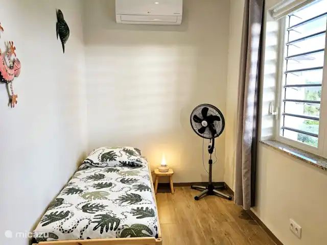 apartamento en Curazao, Curazao Centro, Blue Bay – Casita Caribe + Préstamo de Auto! El segundo dormitorio con 2 camas apilables, aire acondicionado y un ventilador de pie.