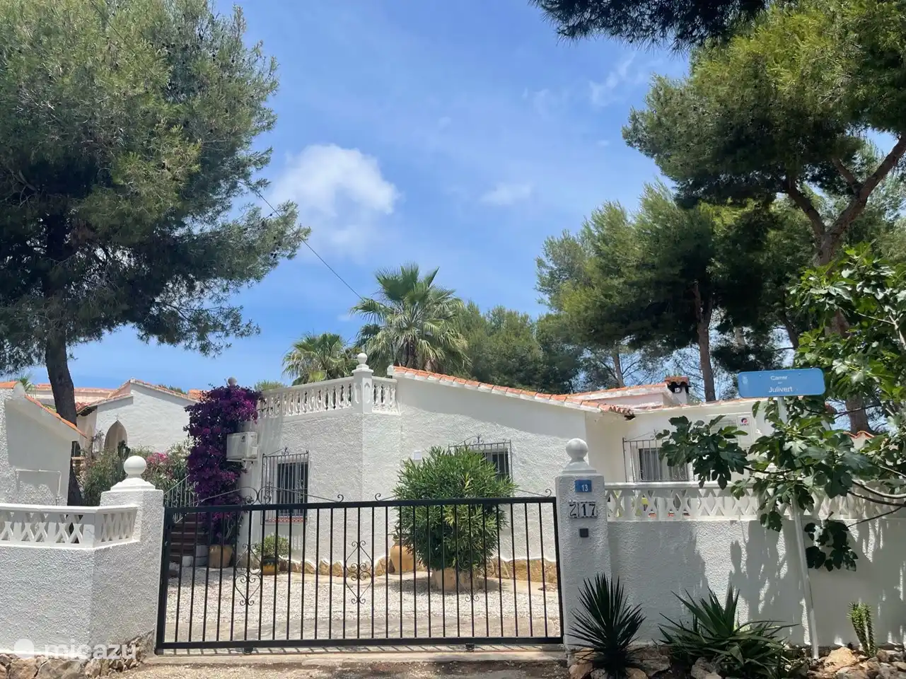 Vue de face le long de la rue. Le terrain est entièrement clôturé