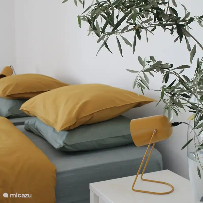 Bequeme Betten mit bunter Bettwäsche für eine sonnige Atmosphäre. 