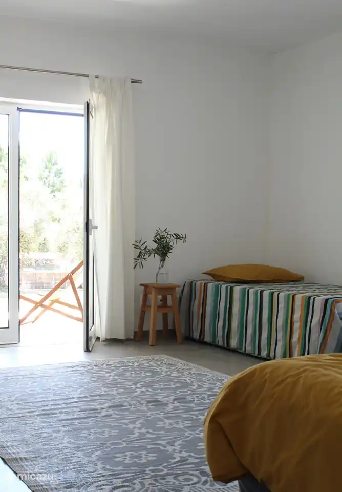 Zimmer 'A Mimosa' mit Terrassentüren zur Veranda.