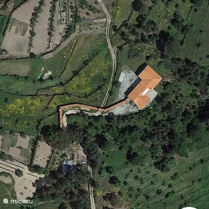 Luftaufnahme der Quinta Levegada. Vor dem Haus befinden sich die verschiedenen Terrassen mit Gras und Oliven- und Obstbäumen. Rechts vor dem Haus auf der 3. Terrasse befindet sich das Schwimmbad im März 2025 zwischen den Olivenbäumen.