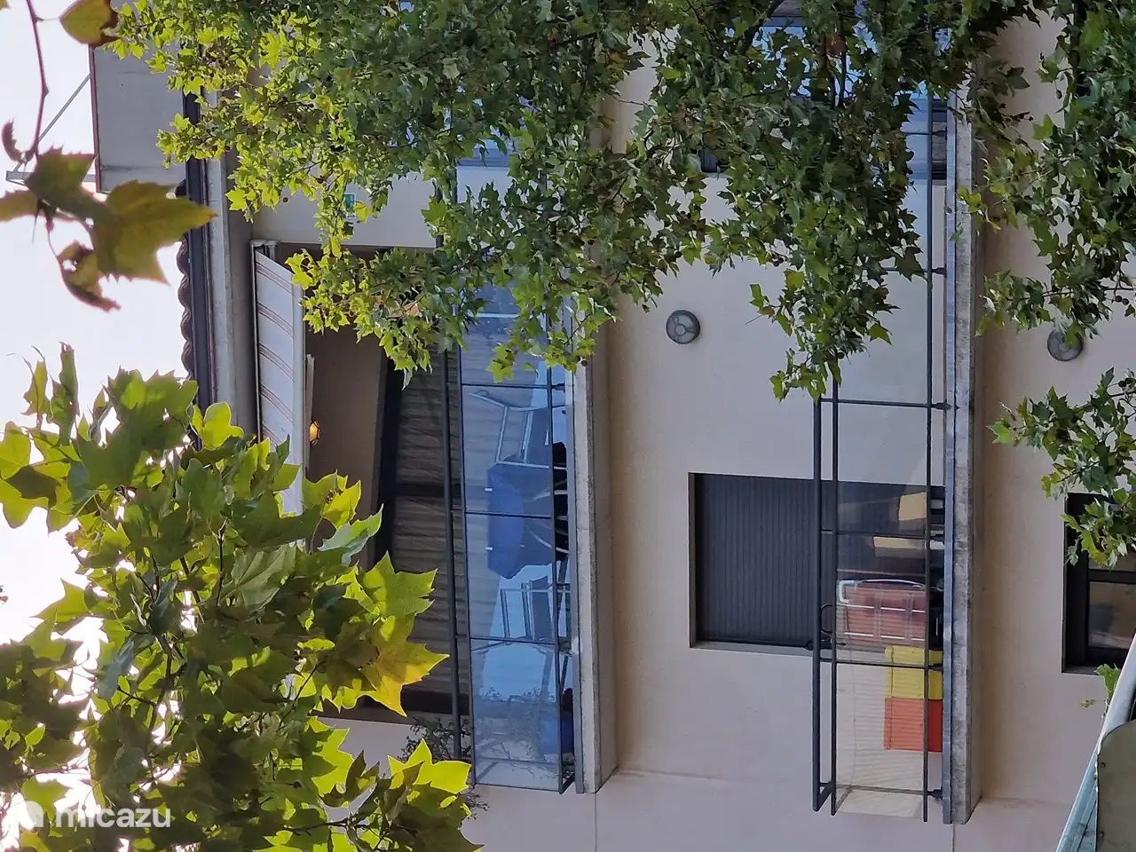 Terrasse am unteren Ende des Wohnzimmers mit großen Schiebetüren, um die Sonne und den Blick auf den darunter liegenden Platz zu genießen. Damit Sie abends das schöne Leben genießen können, ist die Terrasse mit einer elektrischen Markise und Beleuchtung ausgestattet.
