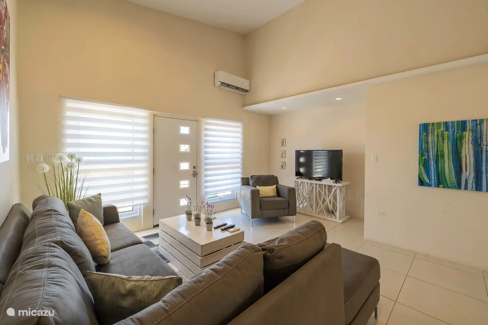 Sala de estar de planta abierta con TV y aire acondicionado