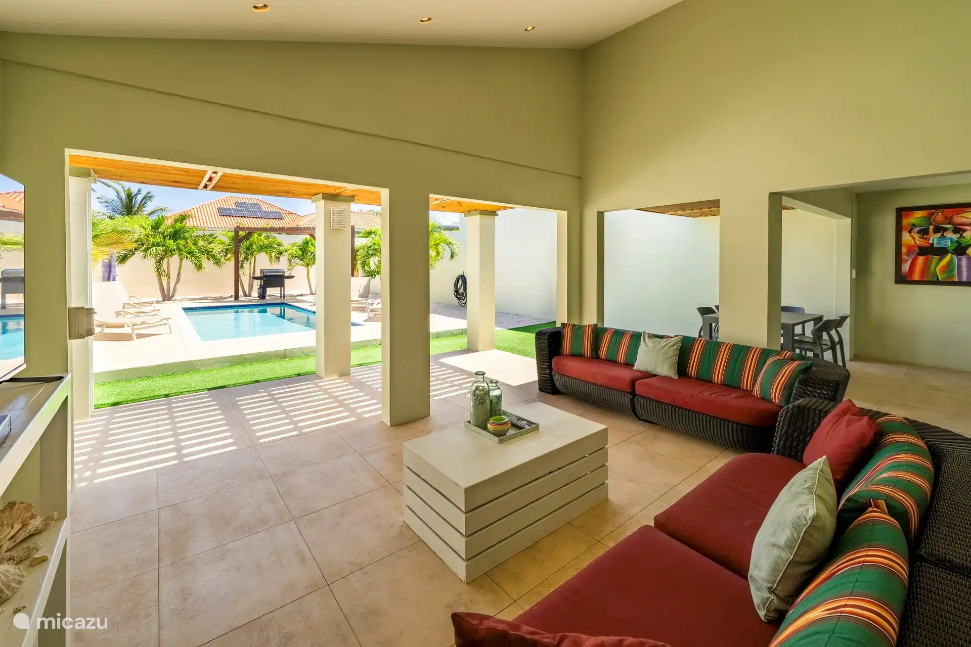 Porche Acter con sofás de salón, mesa de comedor en un acogedor ambiente isleño