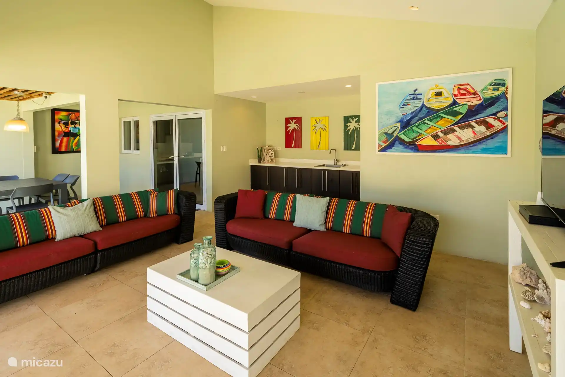 Porche Acter con sofás de salón, mesa de comedor en un acogedor ambiente isleño