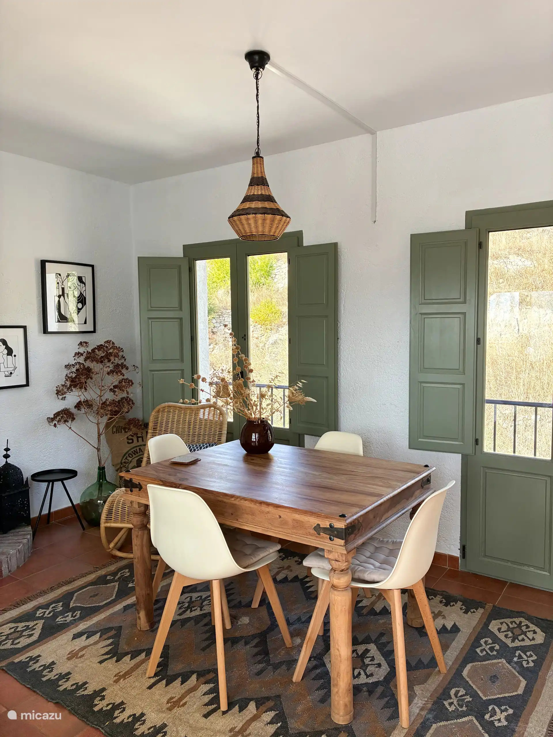 Gemütliches Wohnzimmer mit Sitzecke, Esstisch, Terrassentüren und Holzofen.