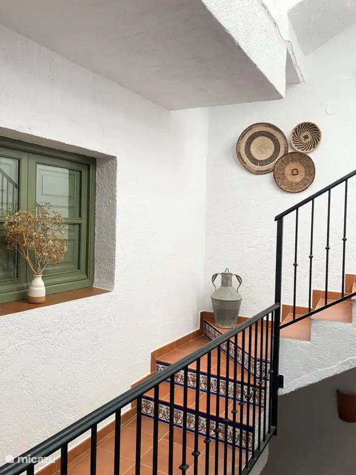 Das Haus verfügt im Erdgeschoss über eine überdachte Terrasse mit einem kleinen Esstisch und einer geräumigen und hellen Treppe.