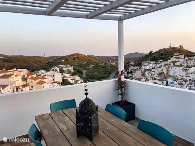 Casa Cubasta | Espagne, Andalousie, Sedella - maison de vacances La terrasse inférieure sur le toit dispose d'une grande table à manger et offre une vue imprenable sur le village blanc de Sedella. Le coucher de soleil est spectaculaire.