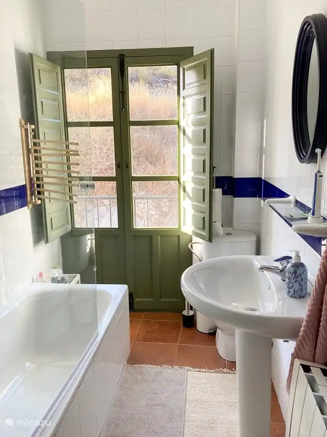 Badezimmer im ersten Stock mit Badewanne, Waschbecken und Toilette. Im Erdgeschoss befindet sich ein weiteres Badezimmer mit Dusche, Waschbecken und Toilette.