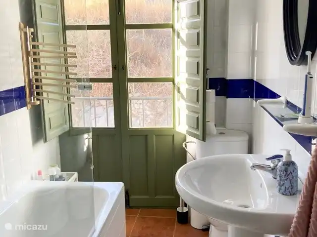 Casa Cubasta | Espagne, Andalousie, Sedella - maison de vacances Salle de bain au premier étage avec baignoire, lavabo et toilettes. Au rez-de-chaussée se trouve une autre salle de bain avec douche, lavabo et toilettes.