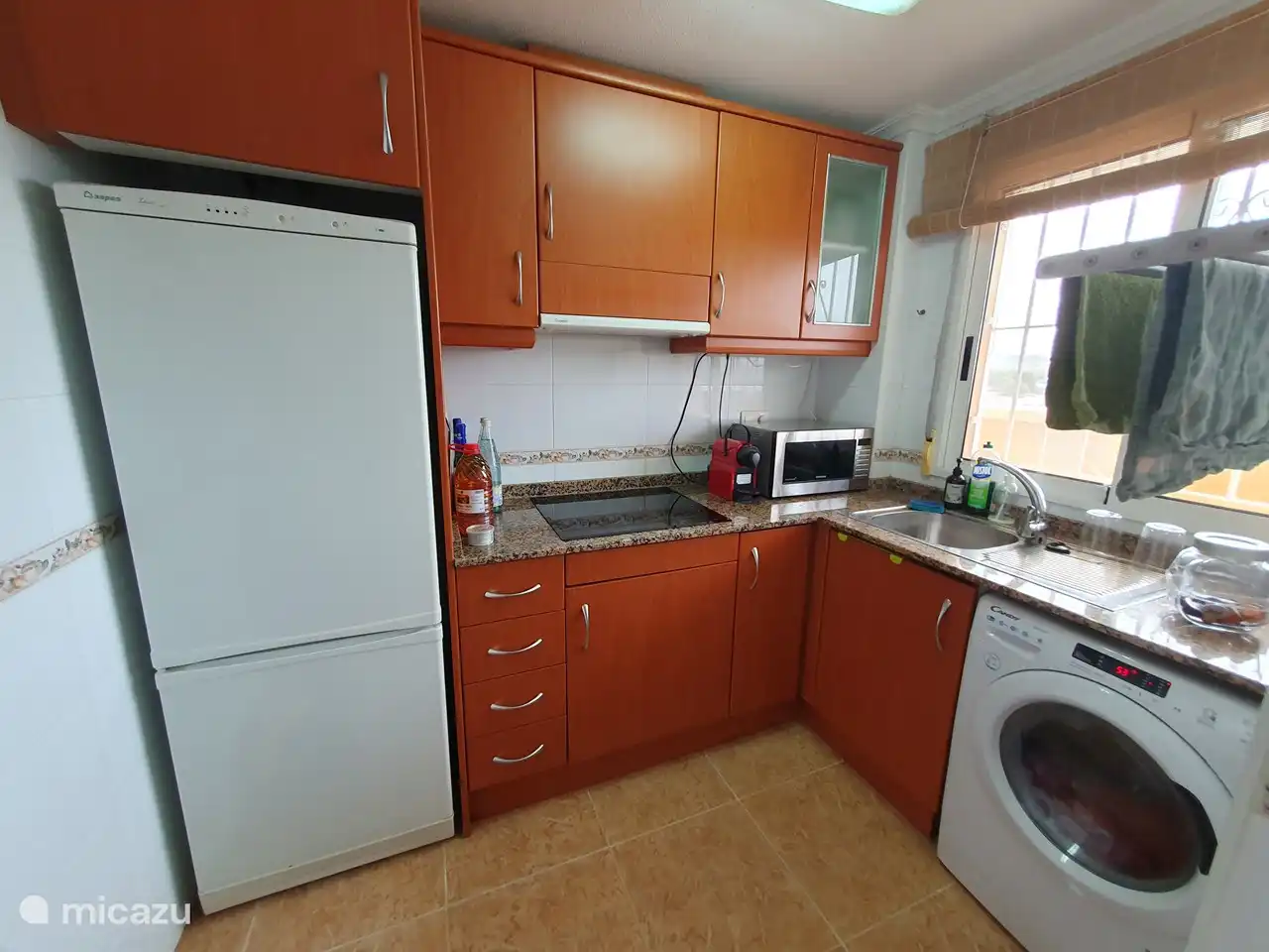 Ingerichte keuken met inductiekookplaat, magnetron, Nespresso machine, waterkoker, wasmachine, ...