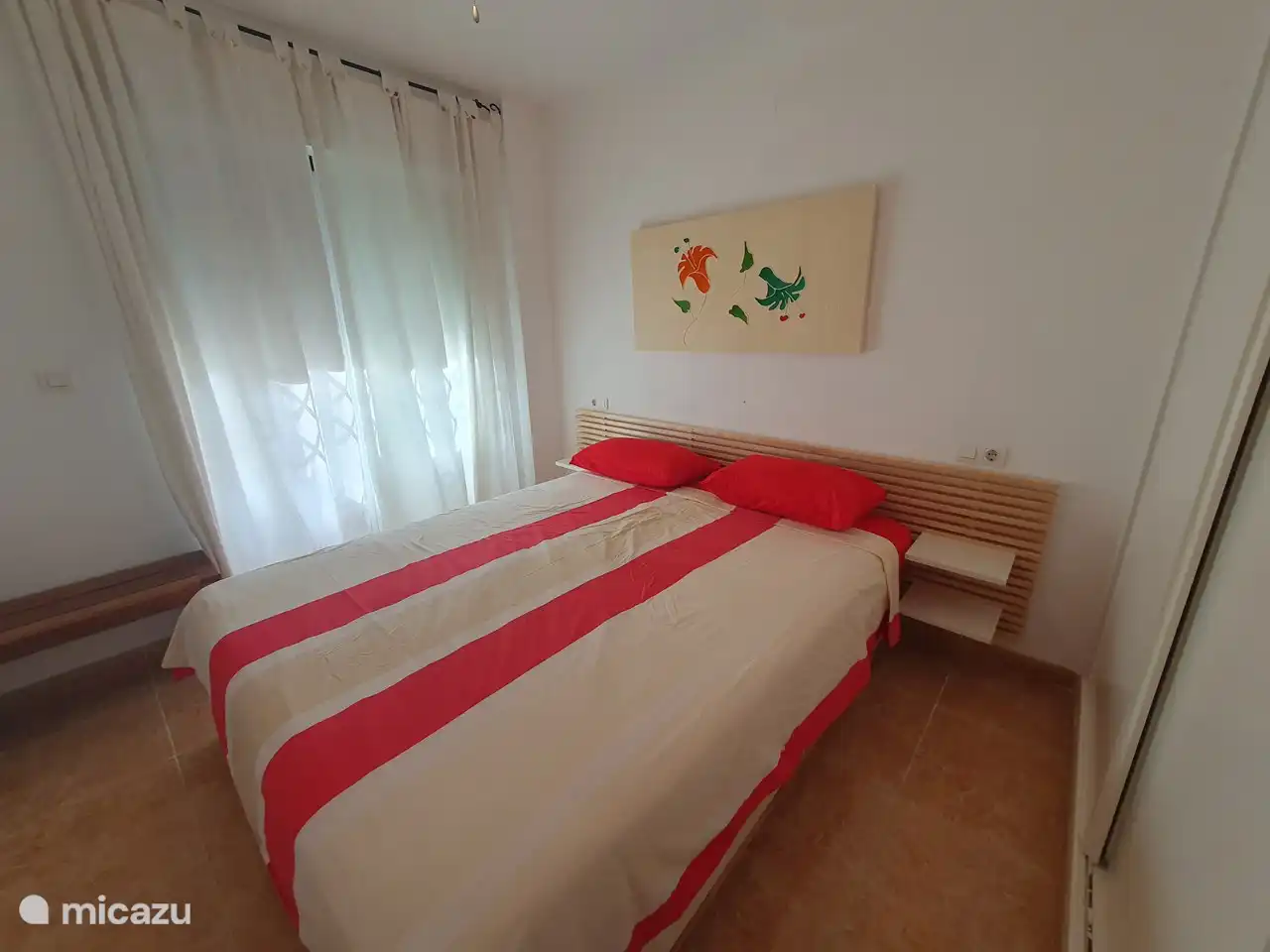 Slaapkamer voorzien van een bed van 1.6 meter breed op 2 m lang en met een plafondventilator. Via de balkondeuren heb je toegang tot het balkon.