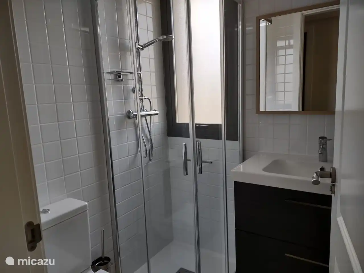 El primer baño ofrece una cabina de ducha, lavabo e inodoro para lo último en comodidad y confort.