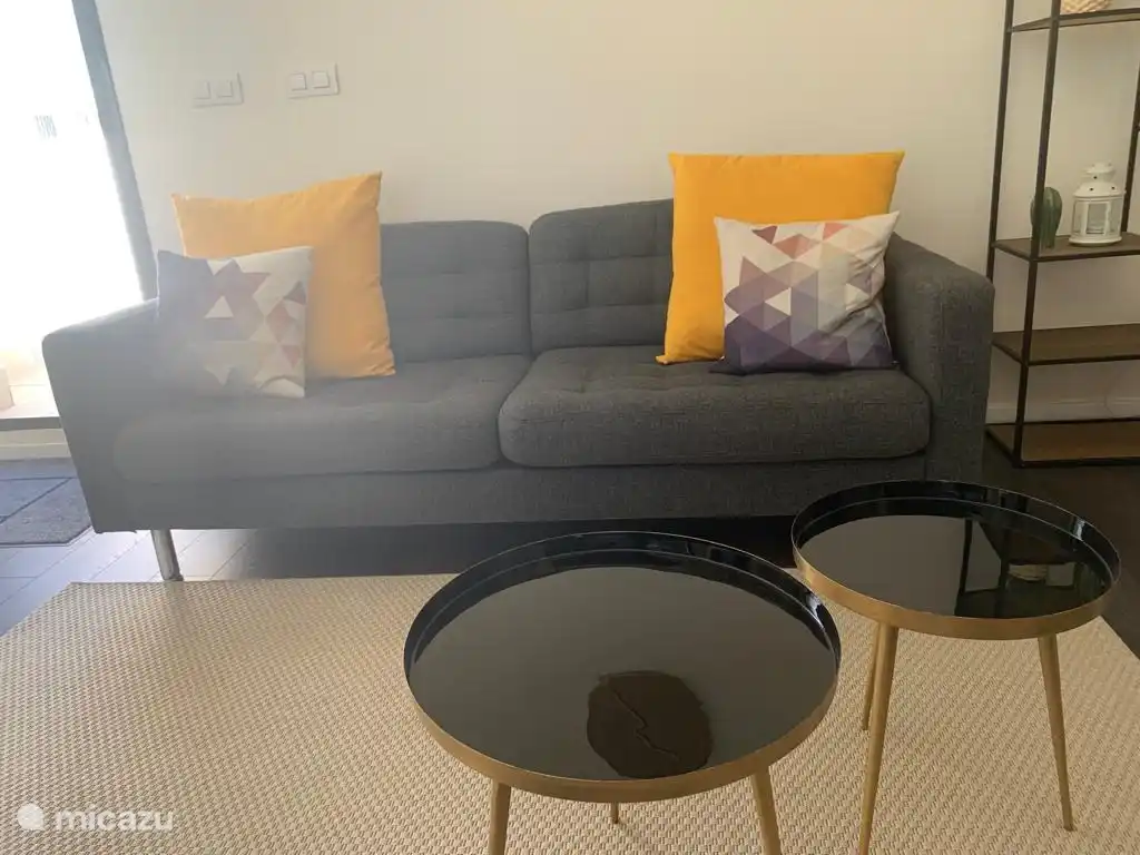 El cómodo sofá invita a sentarse y ver la televisión, un lugar perfecto para el relax y el entretenimiento.