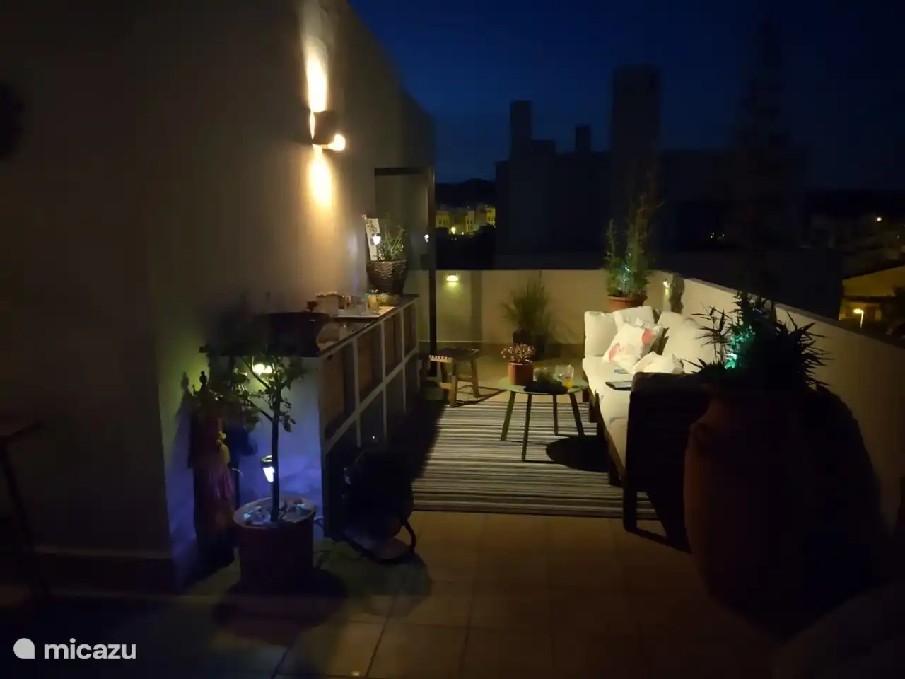 Al atardecer, la azotea con iluminación ambiental se transforma en un lugar encantador para disfrutar y relajarse bajo el cielo estrellado.