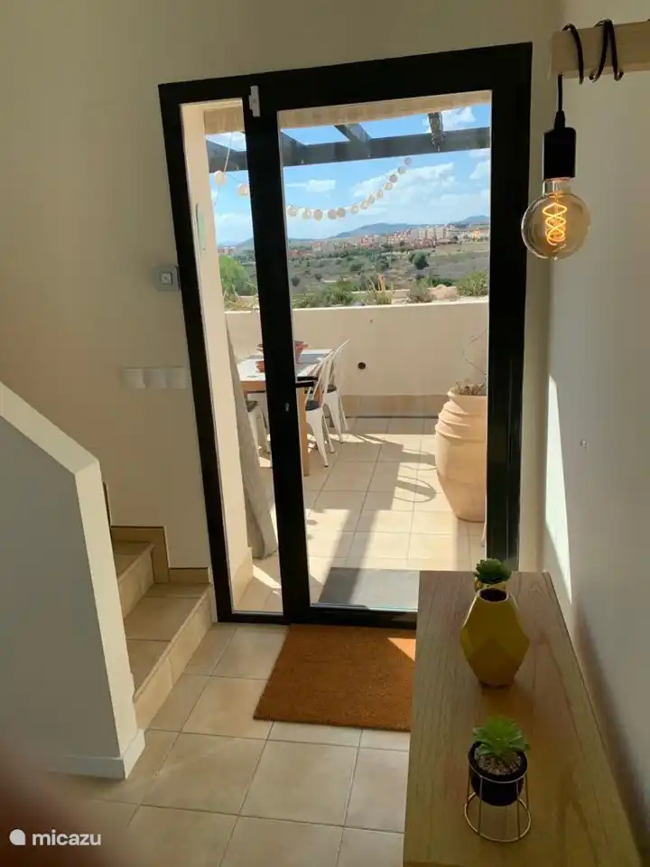 El salón le da la bienvenida con un techo alto, una entrada majestuosa que ofrece una hermosa vista hacia el exterior, donde se encuentran el interior y el exterior.