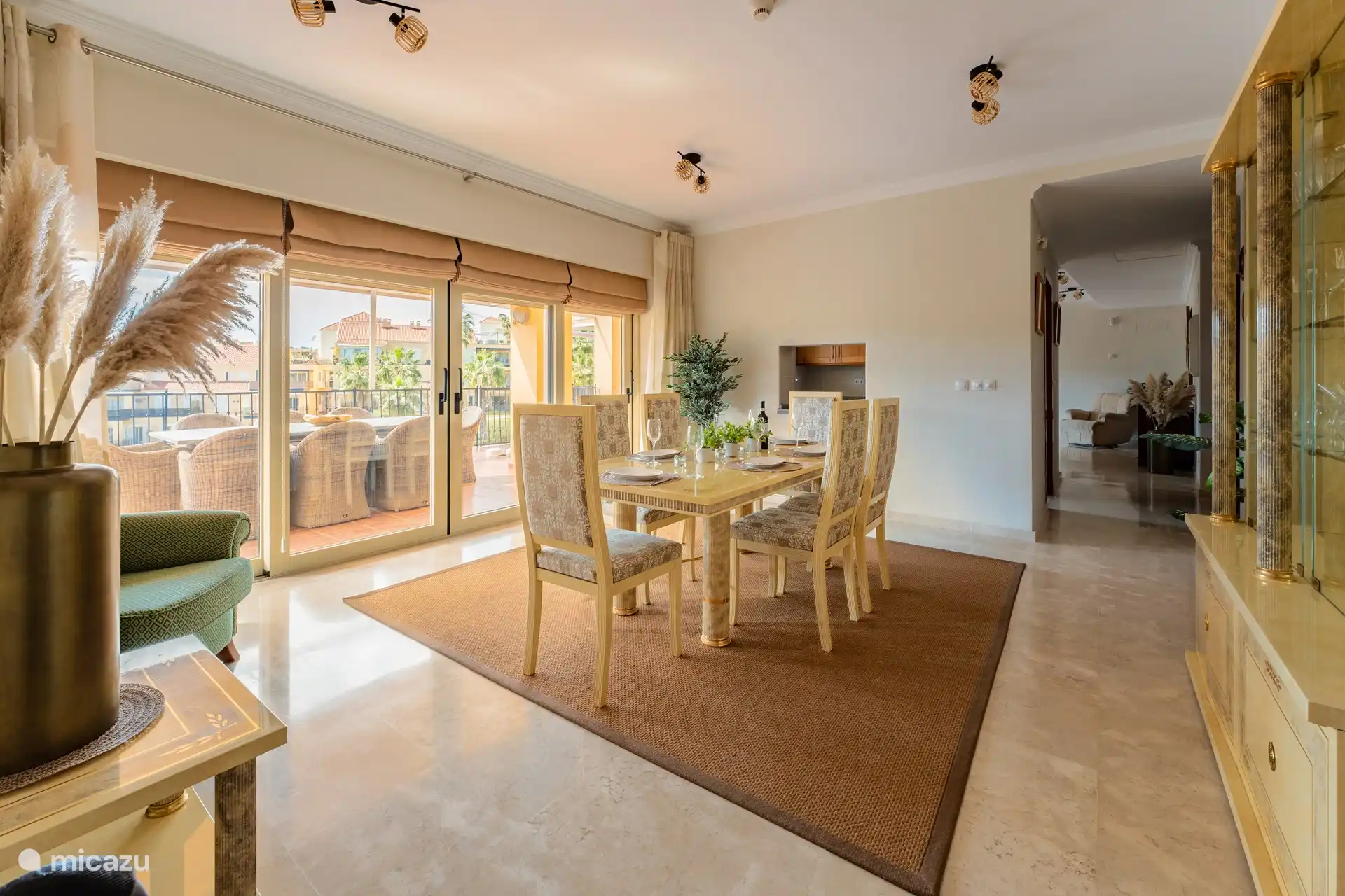 Blick vom Esszimmer auf das Wohnzimmer mit der Küche auf der linken Seite.