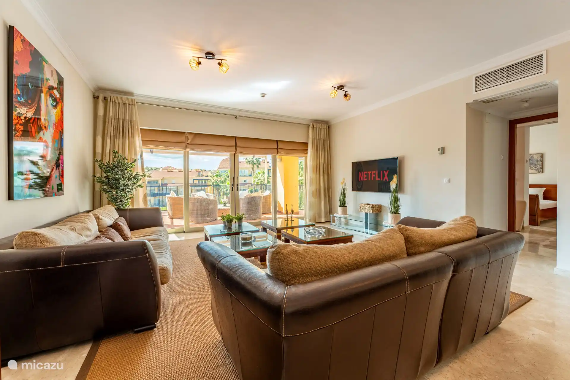 Wohnzimmer mit TV und Zugang zur Terrasse.