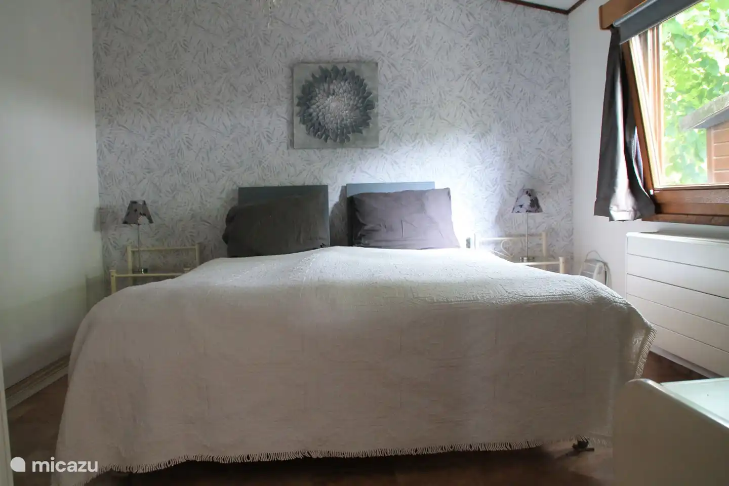 Ein Schlafzimmer mit einem festen Bett mit zwei Matratzen, einem Kleiderschrank, TV und Zentralheizung